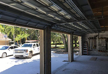 Interior perspective showing reinforced steel framing and double garage door tracks during installation in Clinton, Utah.