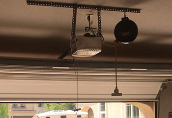 Sectional steel garage door smoothly operating after opener repair in Roy, Utah, with visible opener and track system.