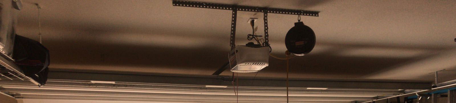 Sectional steel garage door smoothly operating after opener repair in Roy, Utah, with visible opener and track system.