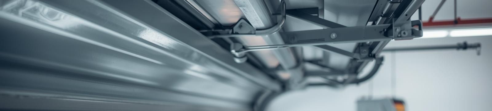 Close-up showing garage door rollers and tracks being inspected in a modern Clinton, UT garage