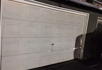 Interior of Clinton, UT garage showing freshly installed white sectional garage door and secure steel tracks.